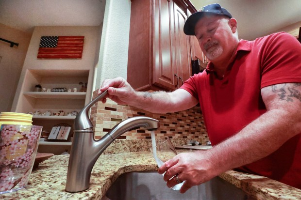 Sanford resident George Sellery pours a glass of tap water in the kitchen of his home in the Lake Forest subdivision, Saturday, July 8, 2023. (Joe Burbank/Orlando Sentinel)