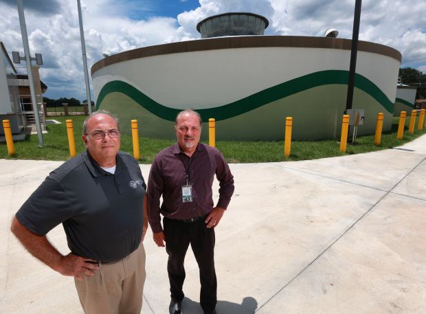 Sanford mayor Art Woodruff, left, and Sanford Public Works utility support manager Bill Marcous, at one of the drinking water storage tanks at Sanford Water Treatment Plant #1 at HE Thomas Parkway, Thursday, July 6, 2023. (Joe Burbank/Orlando Sentinel)